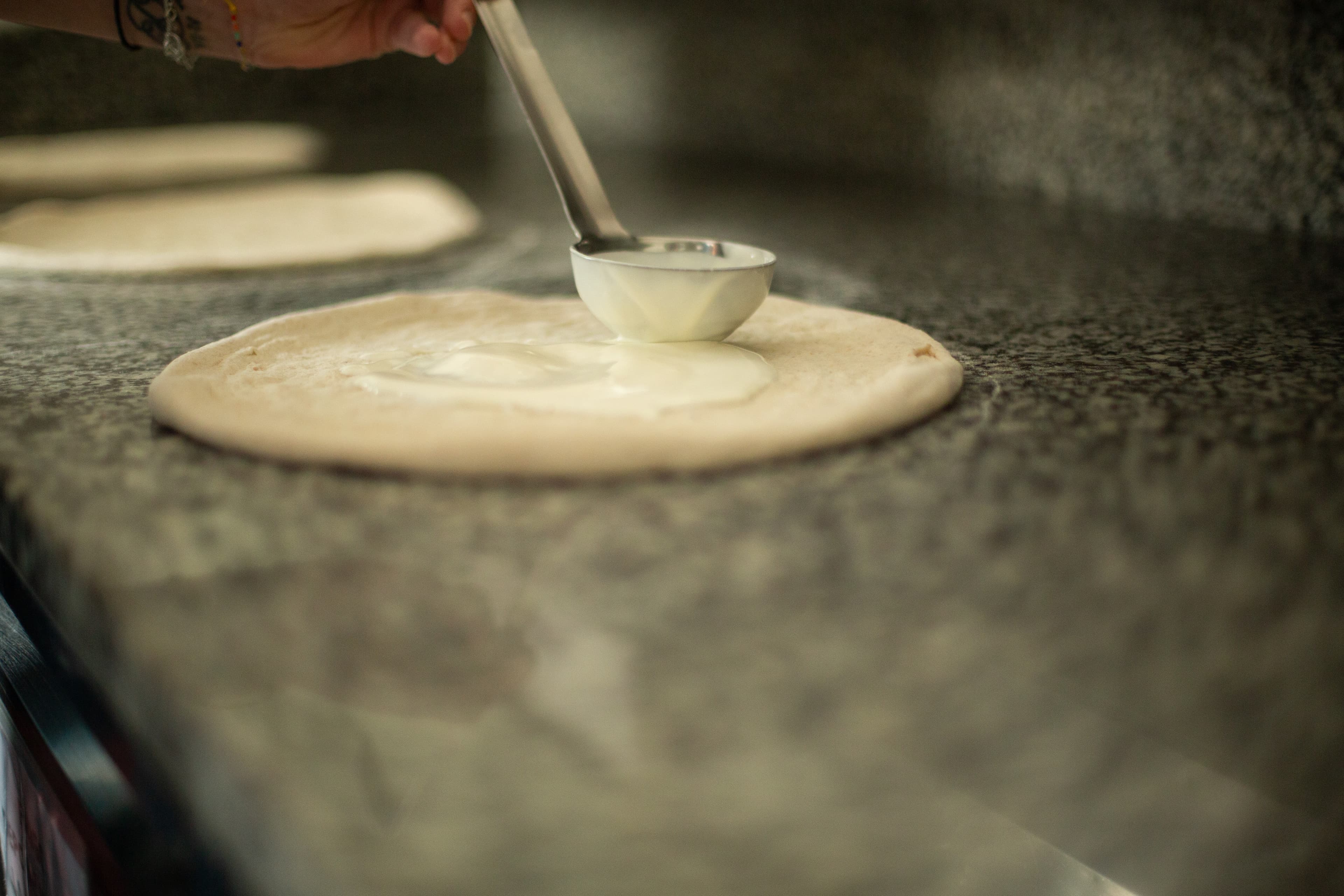Pâte à pizza étirée — test du voile pour vérifier le réseau de gluten